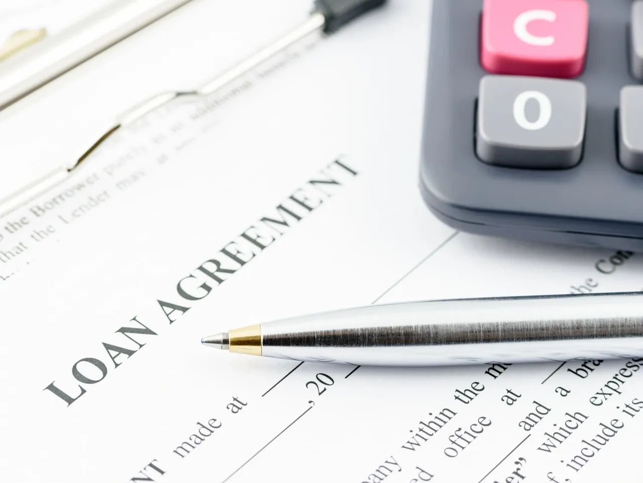 Document labeled Loan Agreement with pen symbolizing contract tracking for loans