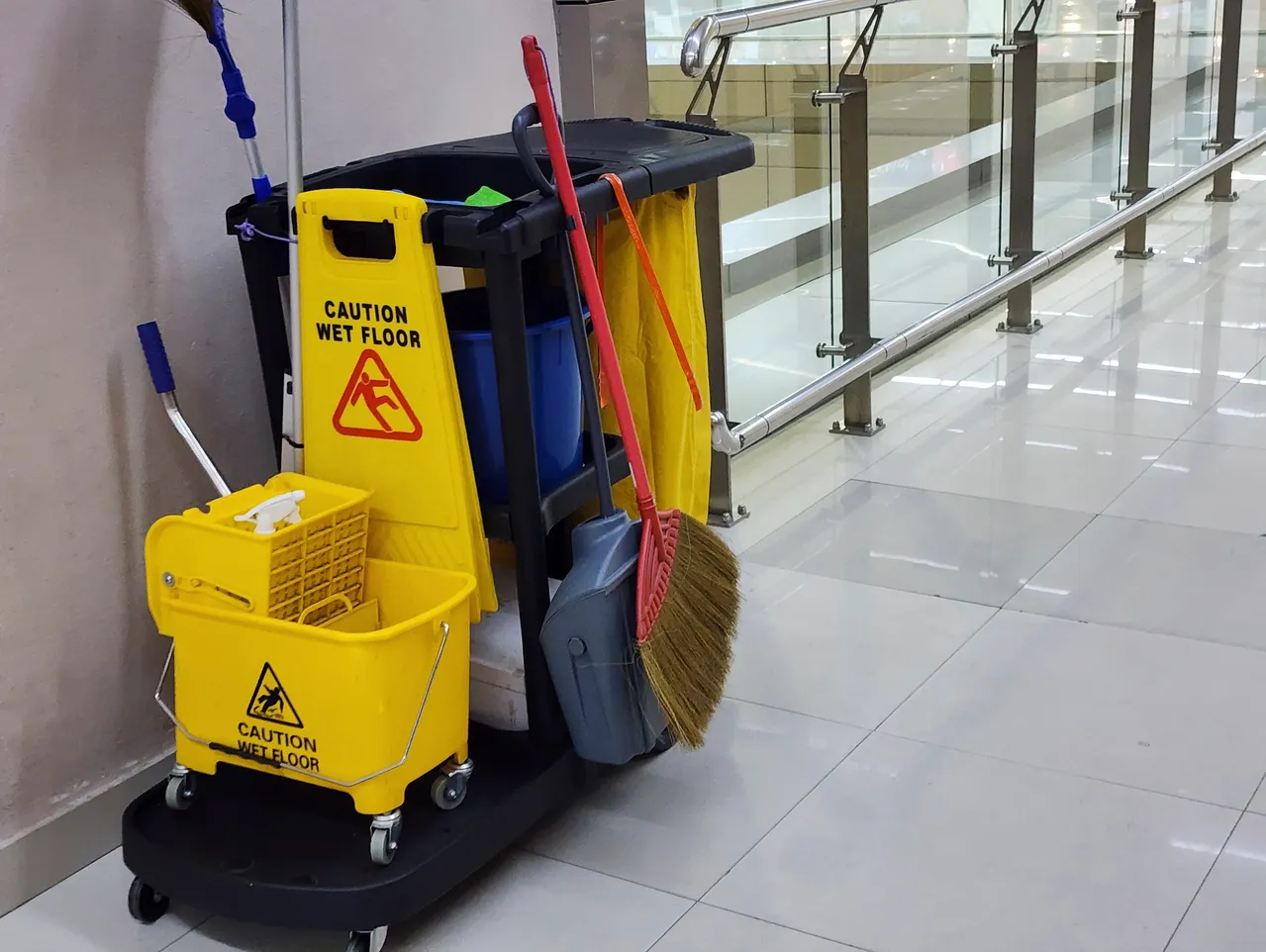 Cleaning cart with caution wet floor sign.
