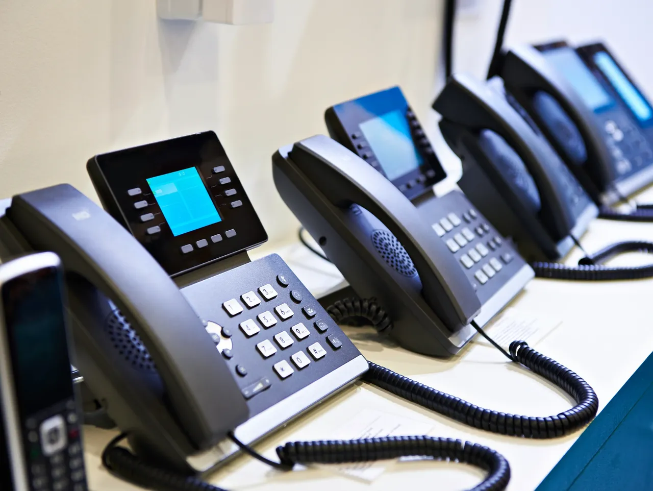 Row of office desk phones representing phone system leases