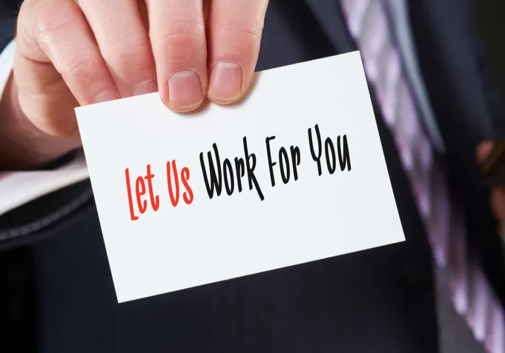 Hand holding a business card that says “Let us work for you,” representing RenewAlert’s copier lease management support for dealers